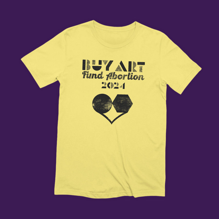 Distressed woodblock-style black print on a pale yellow tee reads "BUY ART, Fund Abortion 2024" with a heart-shaped illustration in which the top section of the heart comprises the shapes of a Mifepristone pill and a Misoprostol pill side by side.