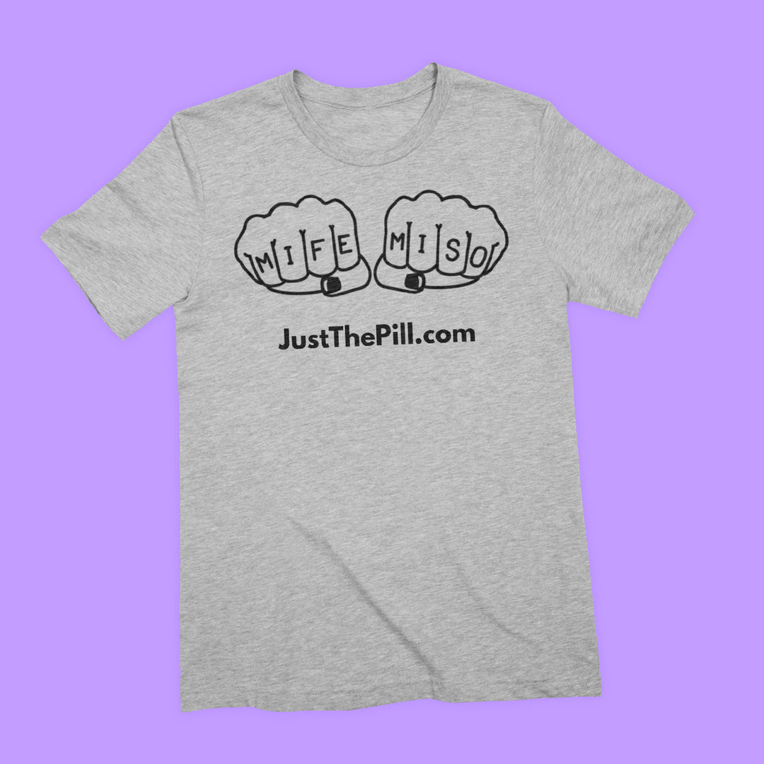 Heather grey tee featuring black print of a line illustration of fists, the knuckles of which read MIFE and MISO. Under the illustration is "JustThePill.com" in sans serif font.